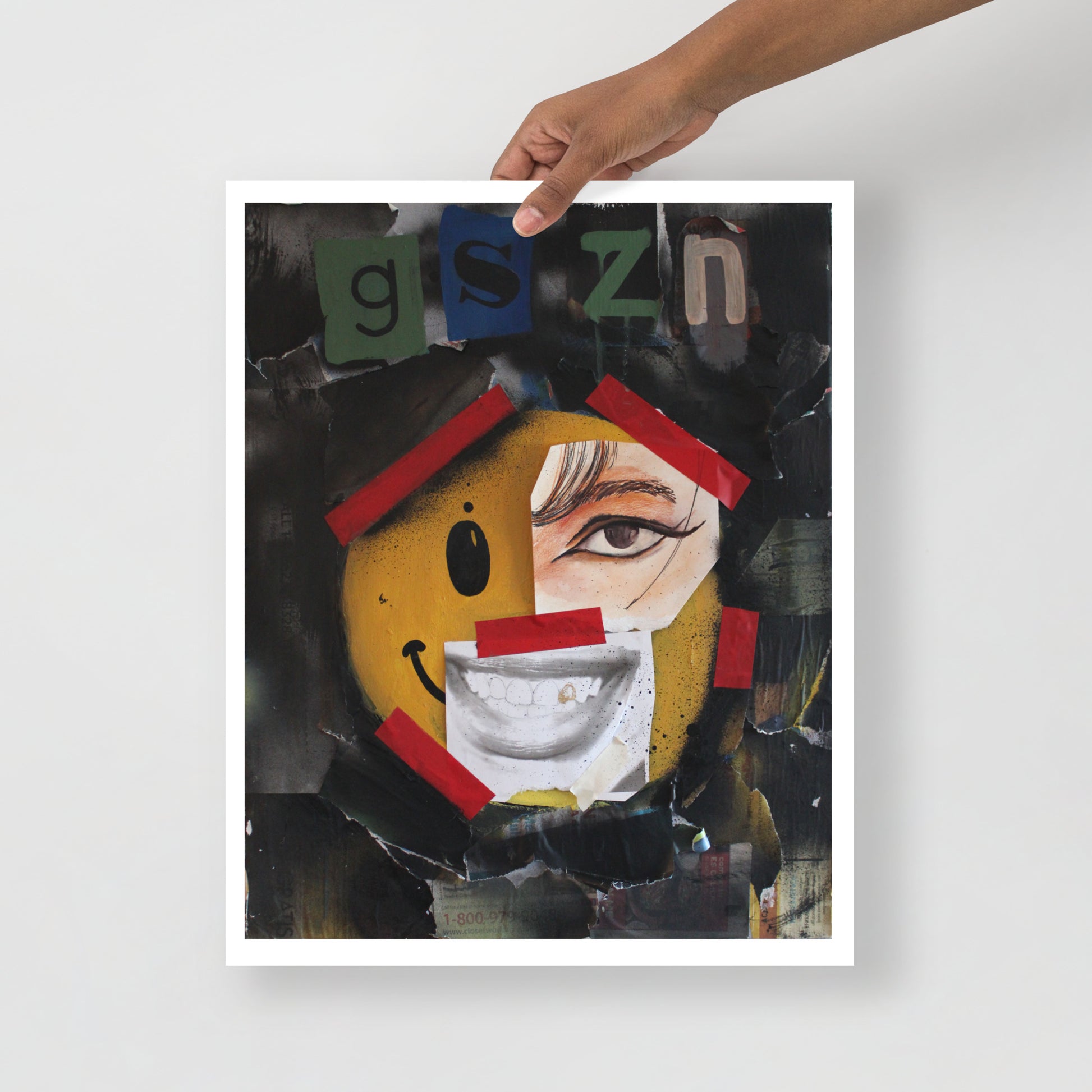 black abstract street art, multi medium art, maximalist art prints, black spray painted paper on painting that says, "G'SZN" at the top of the painting smiley face with red tape as if tape holding smiley face up, newspaper face features; an eye and a mouth, that is supposed to be part of the smile face